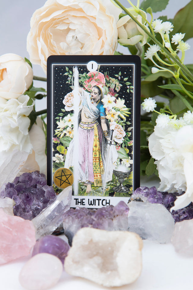 One of the tarot cards from The Intuitive Night Goddess, showing "The Witch" with white roses and amethyst crystals around it